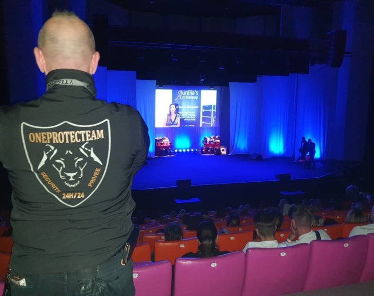 Un policier appuyé sur une rambarde métallique par une journée ensoleillée